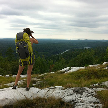Athena Gubbe stares out over the La Cloche mountains into the grand emerald vistas of Killarney Provincial Park